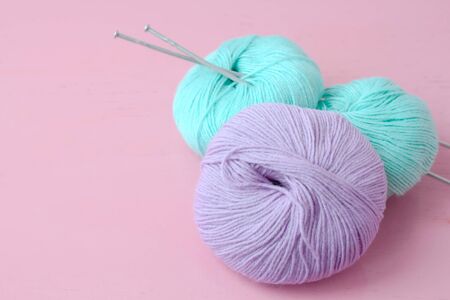 a bright photo with two balls of green-blue color and one ball of lilac color with two spokes on a...