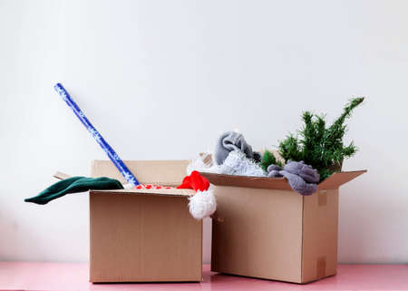 Two cardboard boxes containing an artificial Christmas tree Santa hat and wrapping paperの写真素材