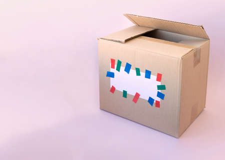 The template for writing on a cardboard box is glued with a white piece of paper with multicolored...