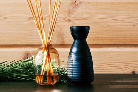 Fir branch and bottles with scent essence on the wooden table in the spa. Healthcare and traditional medicine backdropの写真素材