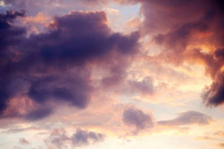 Lush cumulus clouds high in the sky in the rays of the rising sun. Nature backgrounds high up in the...
