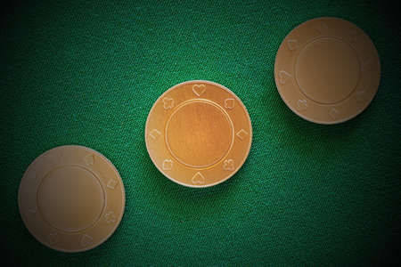 Golden gambling chips under the lamp lights on the poker table in the casino. Gambling and casino...