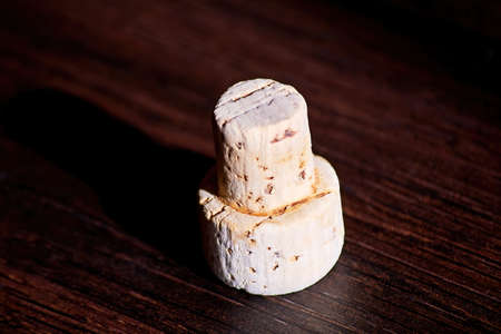A cork from a bottle of red wine lies on a wooden table in the sunlight. Winery and restaurant...