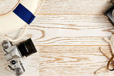 Lifebuoy, vintage camera and beach accessories in the flat lay template. Copy space for advertisement textの写真素材