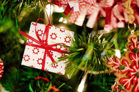 New year tree decorated with a toy box with a gift hanging on a green tree. Christmas backgrounds and texturesの写真素材