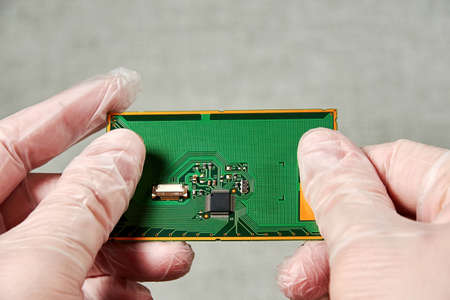 An engineer keeps PCB with a microchip in his hands after development. Nanotechnology and...