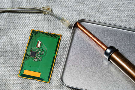 Microchip, pcb, wires, soldering iron in the manufacturing laboratory. Microelectronics and...