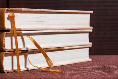 Stack of red ancient books on the brown bookshelf in the library. Science and education backgroundsの写真素材