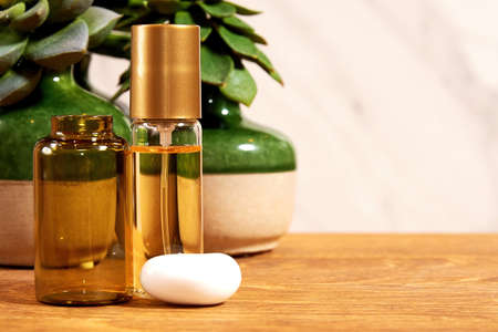 Beauty shop wooden desk with golden liquid perfume and decorative plants. Cosmetics backgrounds with copy space for advertisement textの写真素材