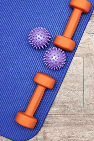 Fitness massage balls and dumbbells on the soft sports mat. Workout concept and accessoriesの写真素材