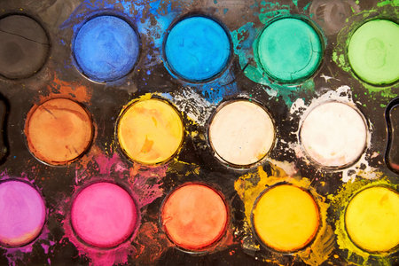 Flat view of messy black paints palette with color splashes and mixings. Crafts, artistic and hobby backgrounds.の写真素材