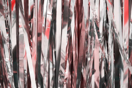 Texture of pink foil for wrapping gifts for the holidays. Abstract festive backgrounds and patterns