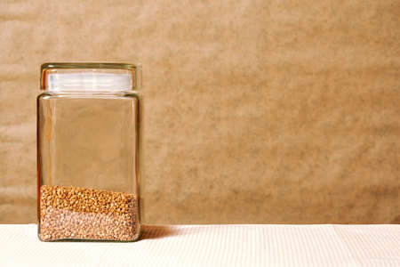 Bank with buckwheat on the kitchen table, still life. template with a copy space for advertisement textの写真素材