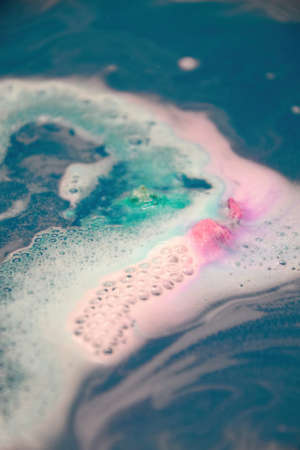 Colorful foam and bubbles in the bath blue water. Abstract backgroundsの写真素材