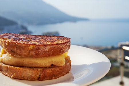 French toast with banana and cinnamon on the terrace of a seaside hotel. Summer holidays and travelの写真素材