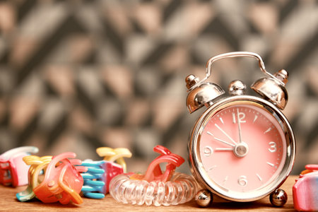Sepia toned image of girls bed table with some accessories and alarm clock. Fashion and youth backgroundsの写真素材