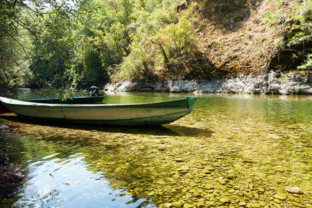 Traditional wooden boats on the coast of the shallow river. Simple water transportations
