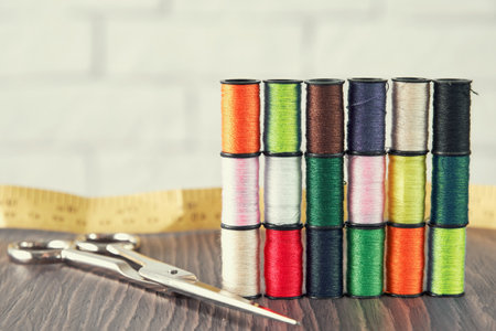 Seamstress working place with threads, scissors and measuring tape. Embroidery and sewing industry....