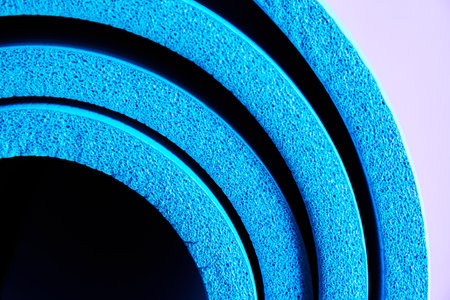 Side close up view of soft foam blue exercises rolled mat. Sports and yoga equipment backgroundsの写真素材