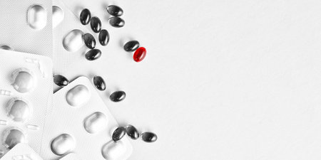 Banner with medical pills, tablets with selected red pill. Copy space with text. Vitamins, painkillers, antibiotics packages. Medicine themeの写真素材