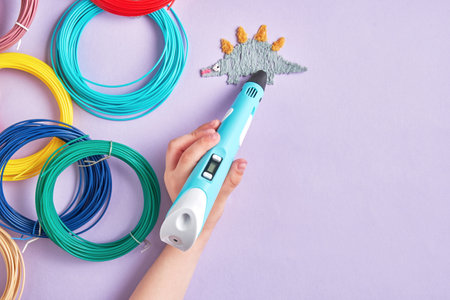 A hand holds a 3D pen and draws a dinosaur on a purple background. Perfect for projects related to...