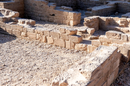 Ancient stone ruins showing weathered brickwork and gravel ground. History of an archaeological site with detailed masonryの写真素材