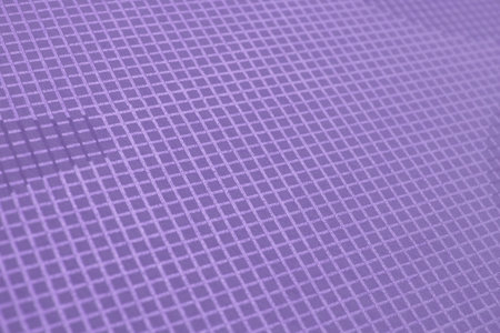 Textured, light purple fabric featuring a grid pattern. The repetitive square design and soft colorの写真素材