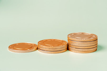 Stacks of golden coins lined up by height from left to right. The coins are arranged in a ascending...