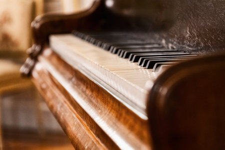 A close-up shot of an antique piano showcasing the ivory and ebony keys. Highlights the craftsmanship and elegance of a vintage musical instrumentの写真素材