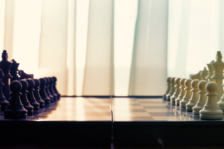 An arranged chessboard with black and white pieces face each other, ready for strategic play