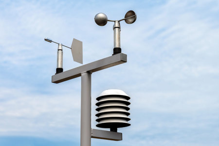 Modern weather station measuring wind speed, direction, and atmospheric conditions against a clear...