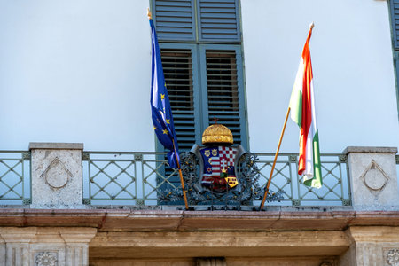 Budapest, Hungary - August 26, 2025: A view of the Hungarian and European flags with the coat of...