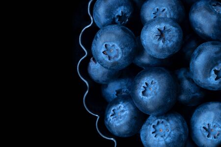 blueberries in a baking dish on a black background, close-upの写真素材