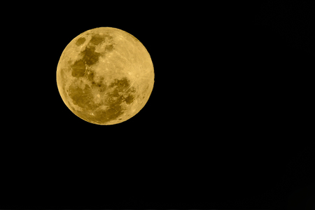Super full moon, beautiful yellow moon with Black background of 20 February 2019 seen from Bangkok, Thailand.の写真素材