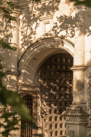 Rustic Wooden Door Set in a Rough-Hewn Stone Wall Arch Columnsの写真素材