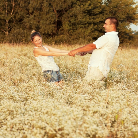 Happy couple enjoying life in the field, playing outdoorsの写真素材