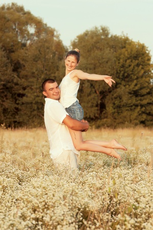 Happy couple enjoying life in the field, playing outdoorsの写真素材