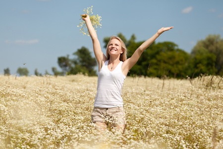 A beautiful young blond girl in a field with white daisiesの写真素材