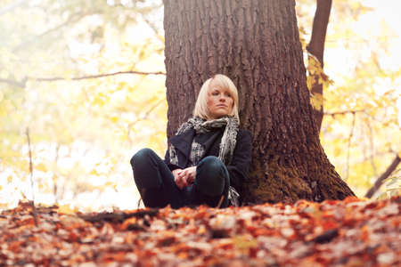 Beautiful girl walking in the autumn parkの写真素材