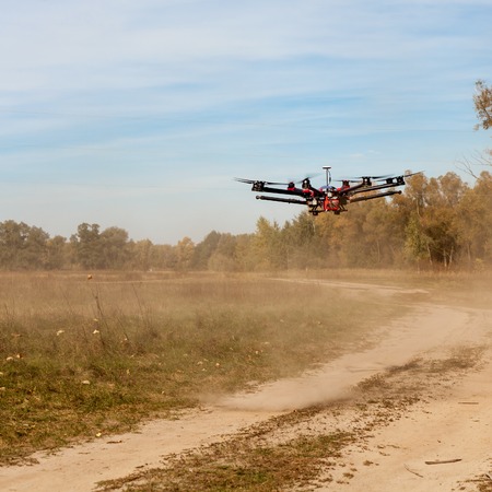 Copter flying at speed. Copter flying above the road and raises for a dust