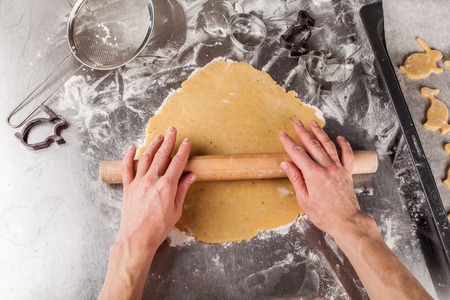 The process of making fragrant Easter cookies with spices and honey from the dough. Woman unrolls...