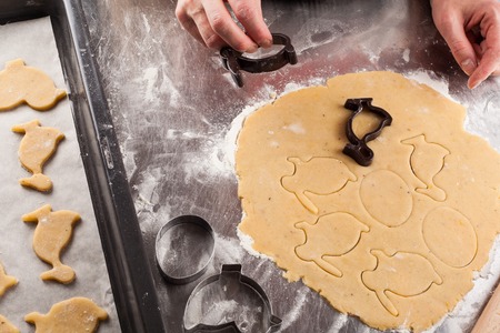 The process of making fragrant Easter cookies with spices and honey from the dough. Woman cuts dough...