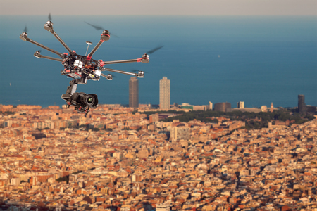 Drone flying in the sky against the backdrop of the beautiful cityscape. Copter is filming the photo...