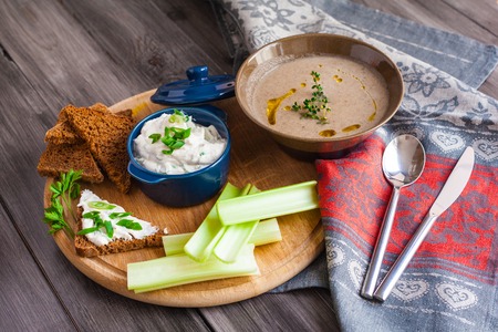 Delicious Creamy Mushroom Soup with cream cheese with herbs and slices of dark bread toast, and...