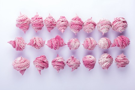 Delicious homemade sweet pink marshmallow with blackcurrant, dusted with icing sugar on a white...