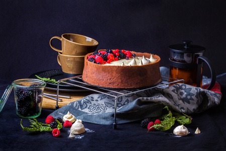 Cake with white chocolate mousse, lime confit, fruits and berries on top as decoration. The process of preparing a tea party with homemade fresh cake.の写真素材