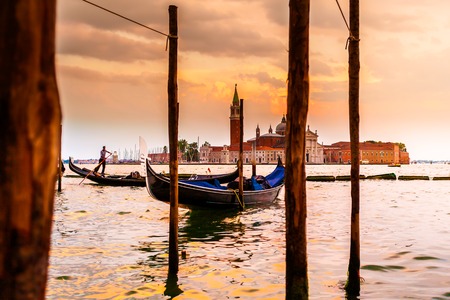 Saint Giorgio Maggiore Church in sunset, view from San Marco embankment. The church with a tower on the island and gondola in the foreground . Venice, Italy. Beautiful sunset sky in the background.の写真素材