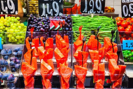 Colourful fruit, figs and vegetables at market stall in Boqueria market in Barcelona. Batch containers with watermelon, grapes, figs close with asparagus, tomato and green pepper.の写真素材