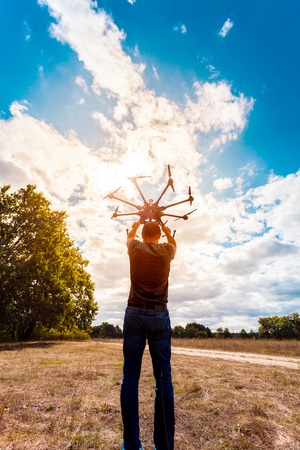 The process of setting up a copter before flight. The man makes all the necessary adjustments before the flight on the drone.の写真素材