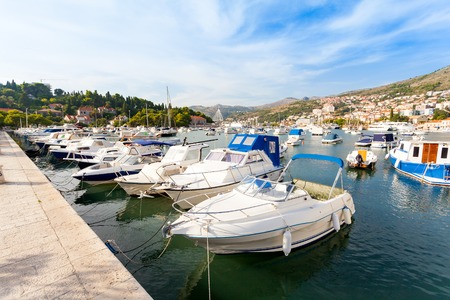 Beautiful sunny day over the bay in front of old town of Dubrovnik. Pier with boats.の写真素材